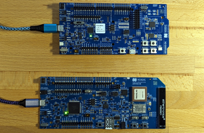 Two blue Nordic development boards on a wooden desk